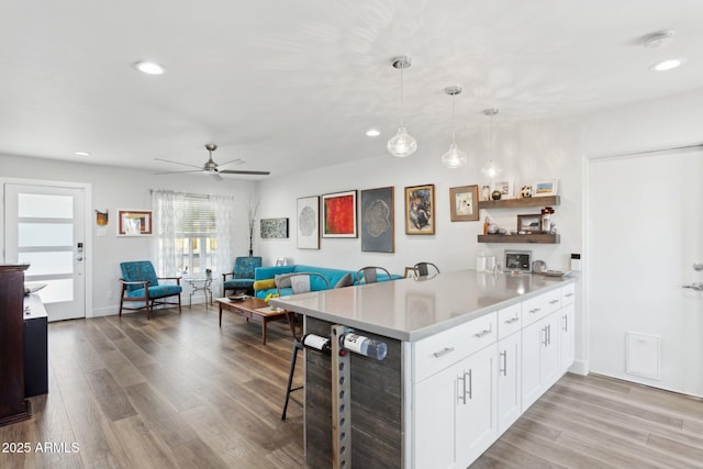 2129 W Indianola Ave, Phoenix, AZ 85015 - kitchen featuring a breakfast bar, a peninsula, light countertops, light wood-type flooring, and recessed lighting