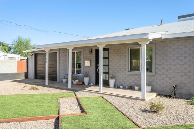 2129 W Indianola Ave, Phoenix, AZ 85015 - rear view of property with driveway, an attached garage, and a porch