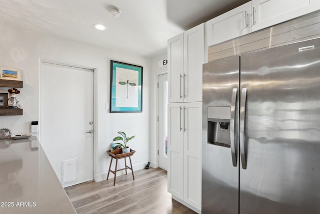 2129 W Indianola Ave, Phoenix, AZ 85015 - kitchen featuring stainless steel fridge with ice dispenser, light wood finished floors, white cabinetry, recessed lighting, and light countertops