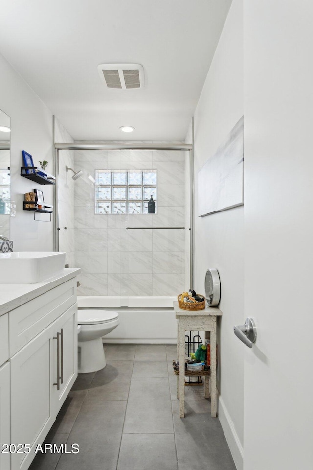 2129 W Indianola Ave, Phoenix, AZ 85015 - bathroom featuring toilet, vanity, bath / shower combo with glass door, and baseboards