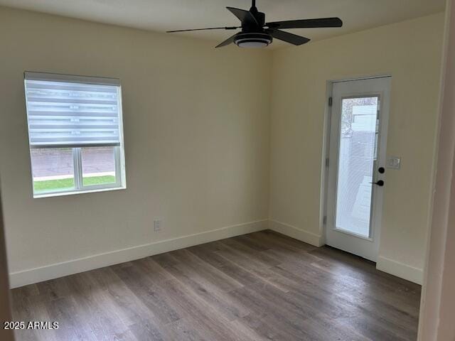 unfurnished room featuring a ceiling fan, baseboards, and wood finished floors