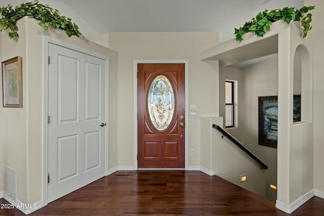 foyer featuring dark wood-type flooring, baseboards, and visible vents