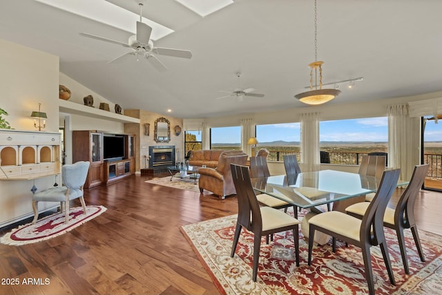 dining room with a ceiling fan, lofted ceiling, and wood finished floors