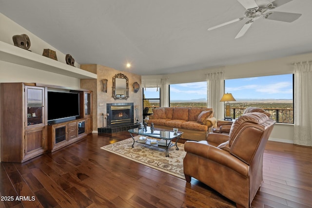 living room with dark wood-style floors, plenty of natural light, a large fireplace, and baseboards