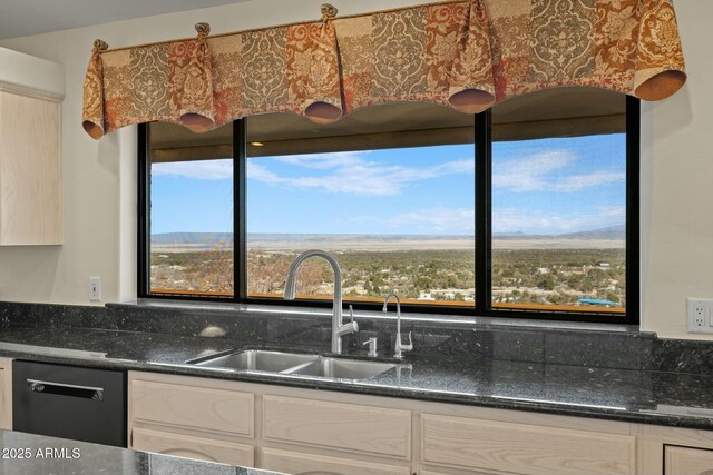 kitchen featuring dishwasher, dark stone countertops, white cabinets, and a sink