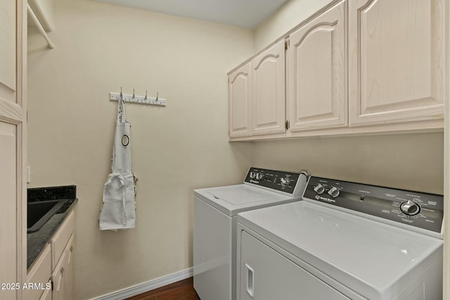 washroom featuring baseboards, cabinet space, and washer and clothes dryer