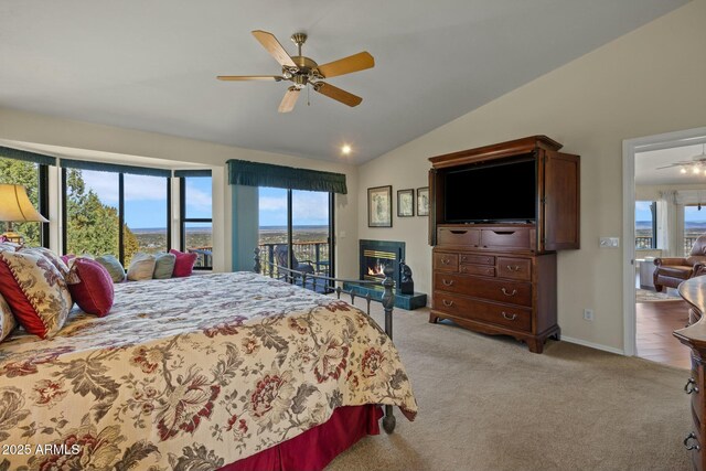 bedroom with a glass covered fireplace, vaulted ceiling, access to exterior, and light colored carpet