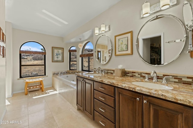 full bath featuring a sink, tasteful backsplash, a bath, and tile patterned floors