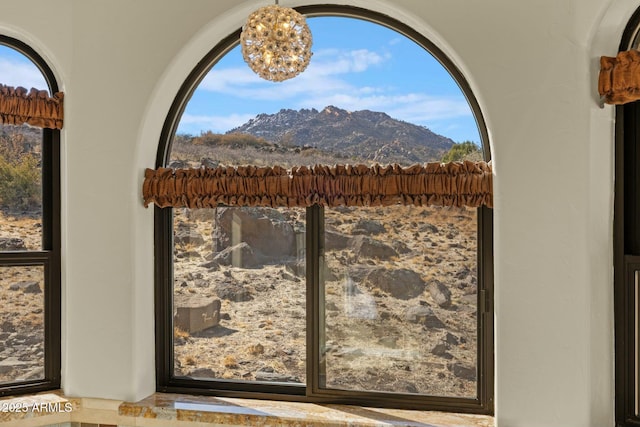 details featuring stucco siding, an inviting chandelier, and a mountain view