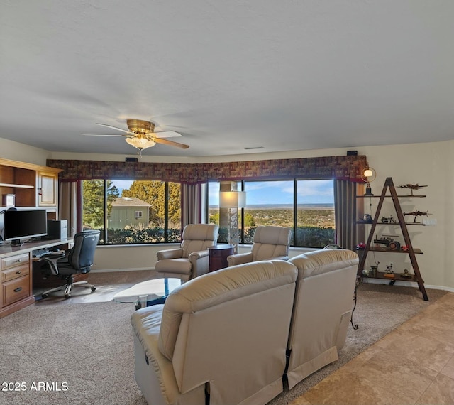 living area with a ceiling fan and baseboards