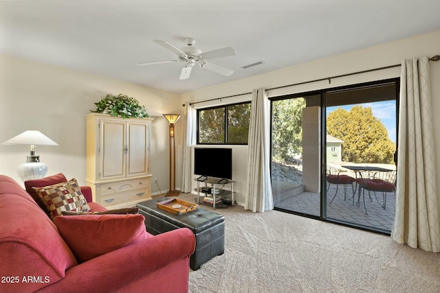 living area with a ceiling fan, visible vents, and carpet floors