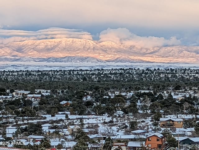 snowy aerial view with a mountain view and a residential view