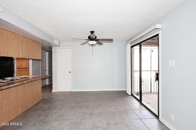 unfurnished living room with a textured ceiling, tile patterned floors, and ceiling fan