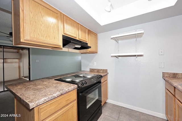 kitchen with electric range, light brown cabinets, light tile patterned floors, and exhaust hood