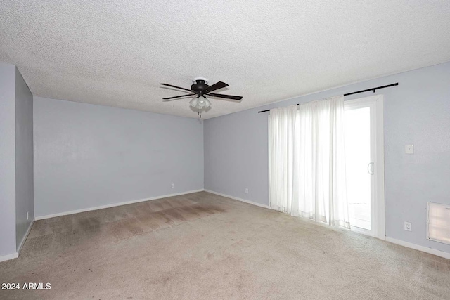 unfurnished room with a textured ceiling, light carpet, and a wealth of natural light