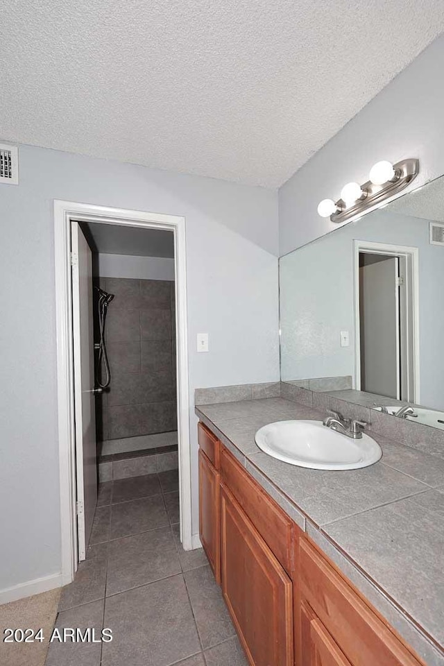 bathroom with a textured ceiling and tile patterned floors