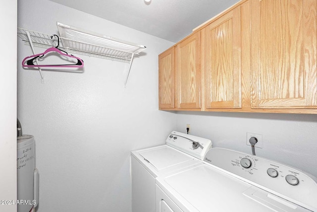 laundry room with cabinets, washer and clothes dryer, and water heater