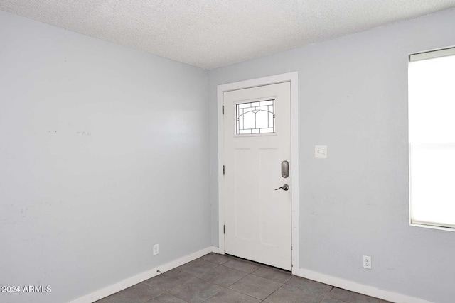 tiled entryway featuring a textured ceiling