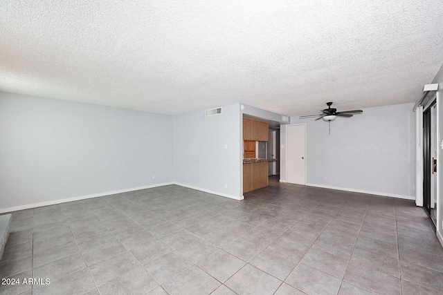 unfurnished living room with a textured ceiling, tile patterned floors, and ceiling fan