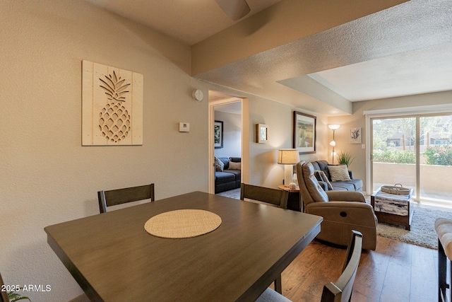 dining room featuring a textured ceiling, hardwood / wood-style floors, and a ceiling fan