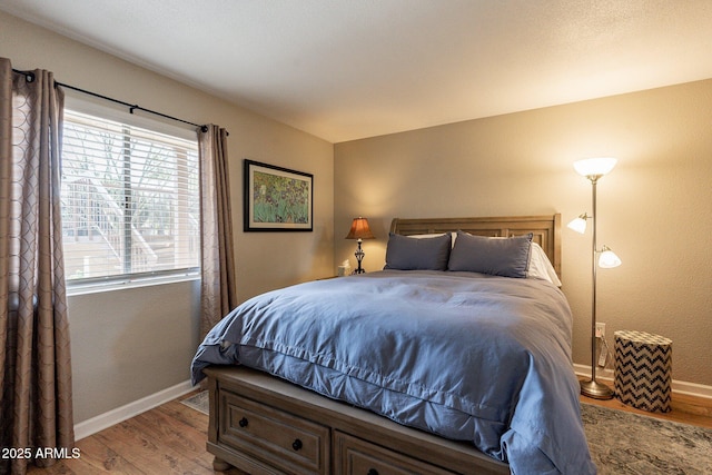 bedroom with baseboards and wood finished floors