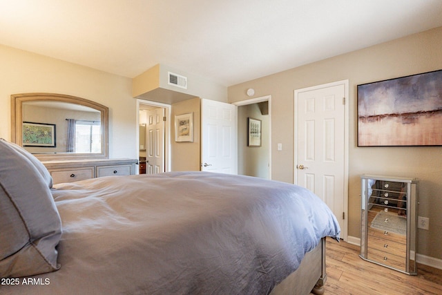 bedroom with baseboards, visible vents, and light wood finished floors