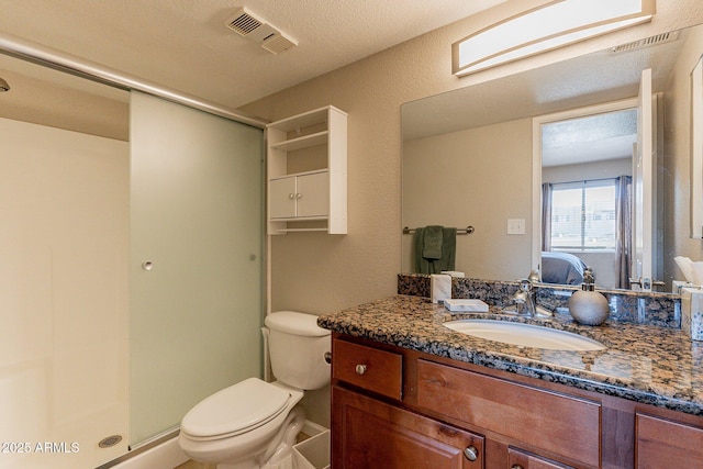 bathroom with vanity, toilet, visible vents, and a stall shower