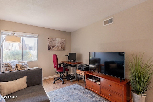 office area featuring visible vents, light wood-type flooring, and baseboards