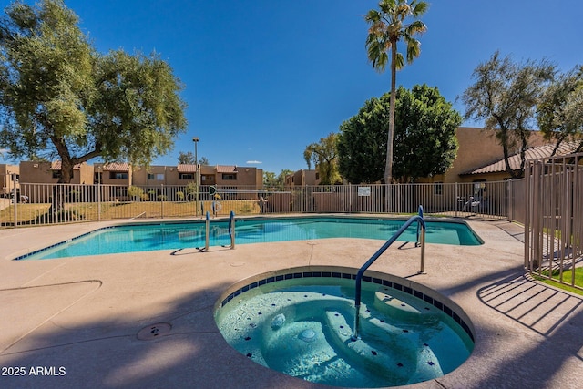 pool featuring a patio area, fence, and a hot tub