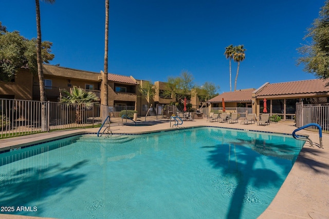 community pool featuring a patio and fence