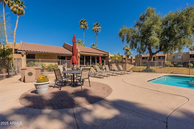 pool with a patio and fence