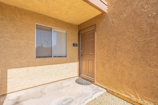 view of exterior entry featuring stucco siding