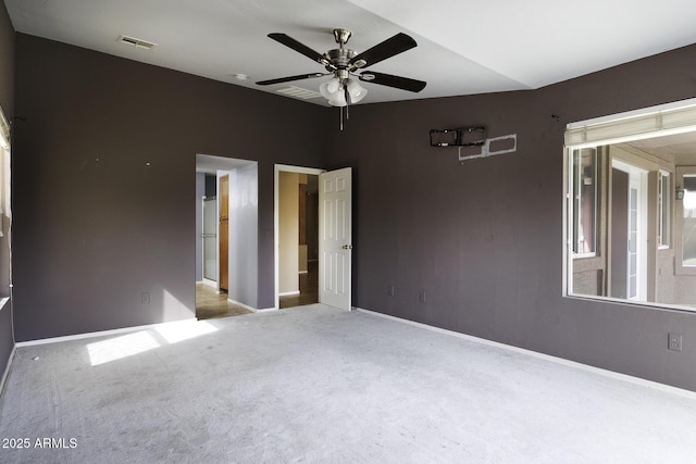 carpeted spare room featuring visible vents, ceiling fan, and baseboards