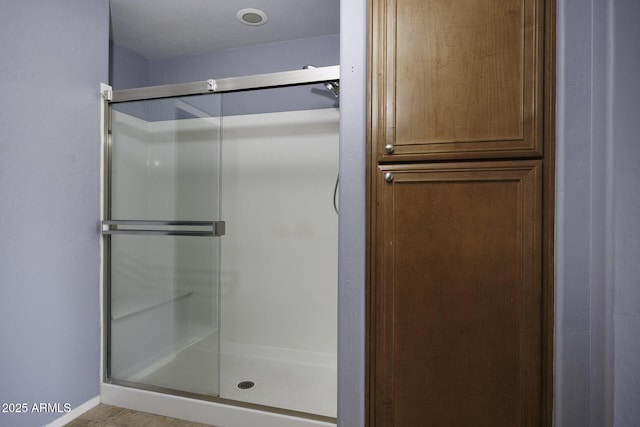full bathroom with a stall shower and baseboards