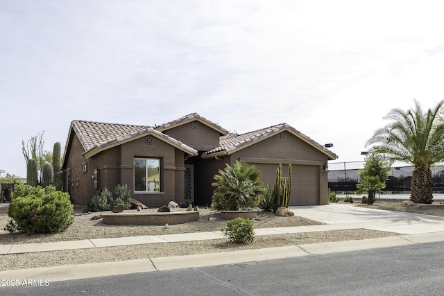 single story home featuring a tiled roof, concrete driveway, a garage, and stucco siding