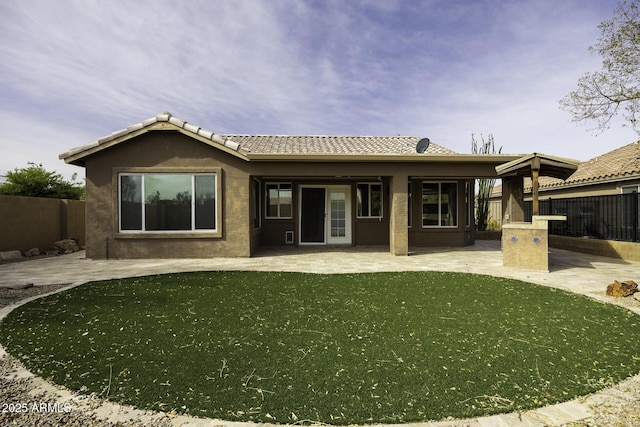 rear view of property featuring a patio, a yard, a fenced backyard, and stucco siding