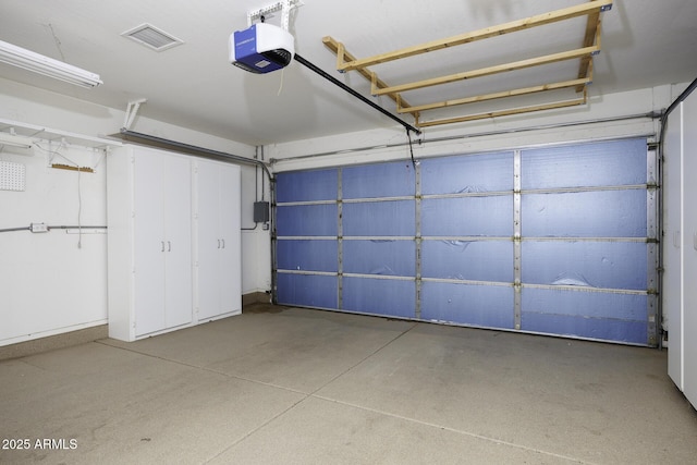 garage featuring a garage door opener and visible vents