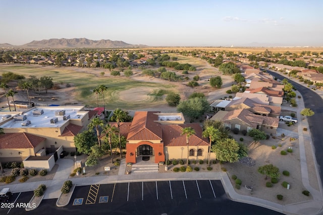 drone / aerial view with a mountain view, golf course view, and a residential view