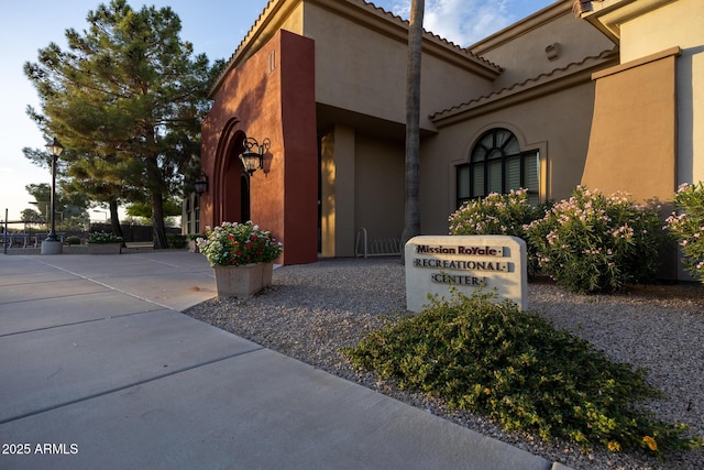 exterior space featuring a tile roof and stucco siding
