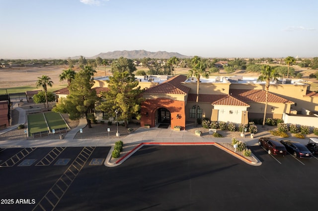 view of front of property featuring stucco siding, a tiled roof, a mountain view, and uncovered parking