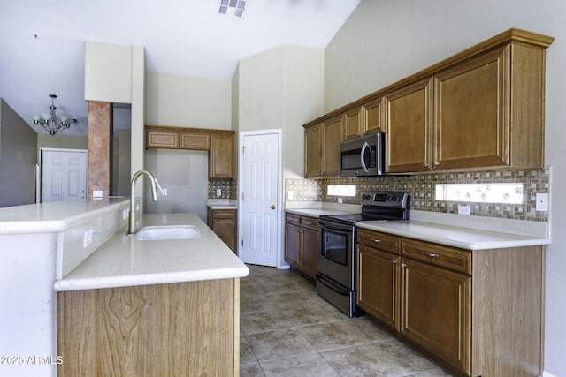 kitchen with an inviting chandelier, backsplash, visible vents, stainless steel appliances, and a sink