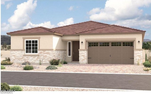 mediterranean / spanish-style home featuring driveway, stucco siding, a garage, stone siding, and a tiled roof