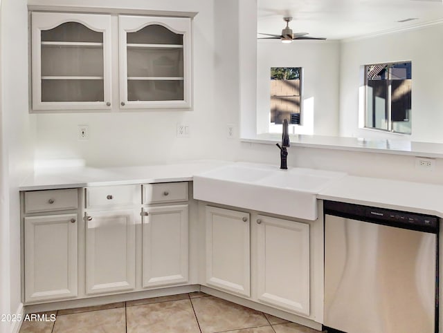 kitchen featuring ceiling fan, sink, white cabinets, stainless steel dishwasher, and light tile patterned flooring