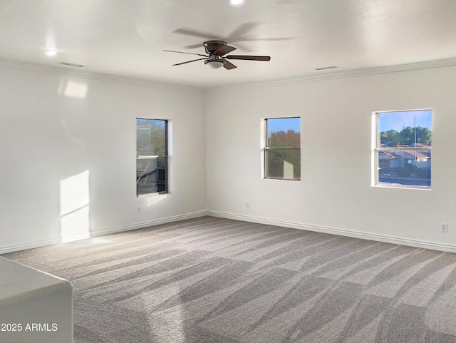 carpeted spare room featuring ceiling fan and crown molding