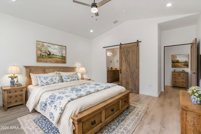 bedroom with lofted ceiling, a barn door, ceiling fan, and light hardwood / wood-style flooring