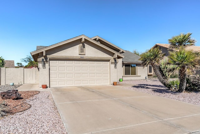 view of front facade with a garage, concrete driveway, fence, and stucco siding