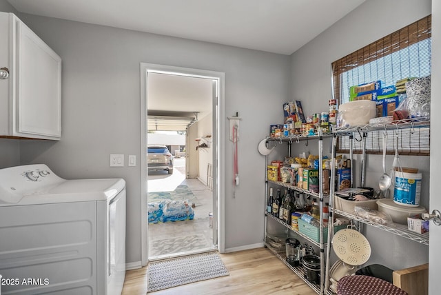 laundry room with cabinet space, washing machine and clothes dryer, light wood-style flooring, and baseboards