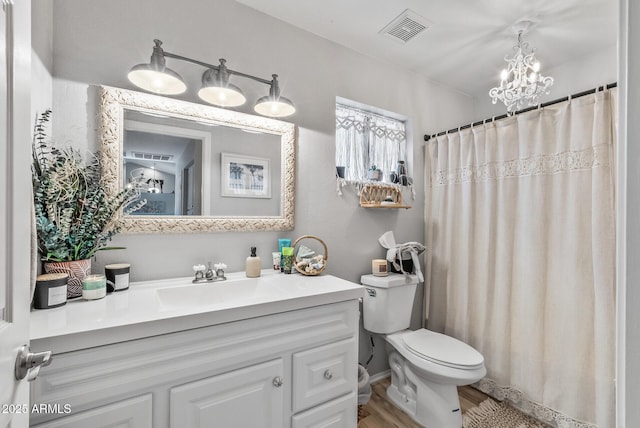 full bathroom featuring visible vents, a shower with shower curtain, toilet, vanity, and a chandelier