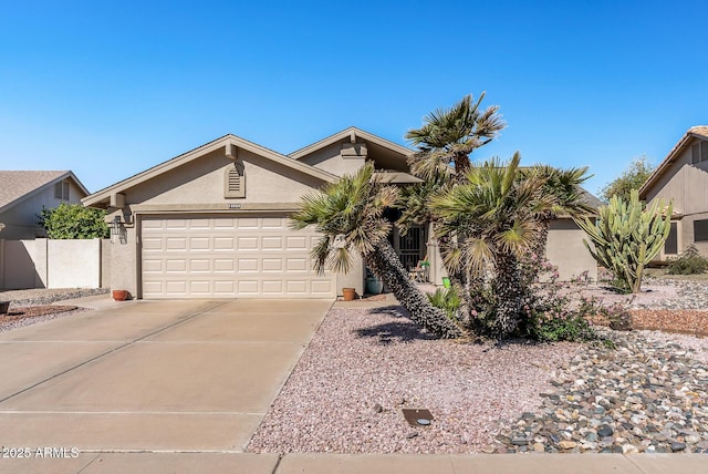 view of front of house featuring a garage, concrete driveway, and stucco siding