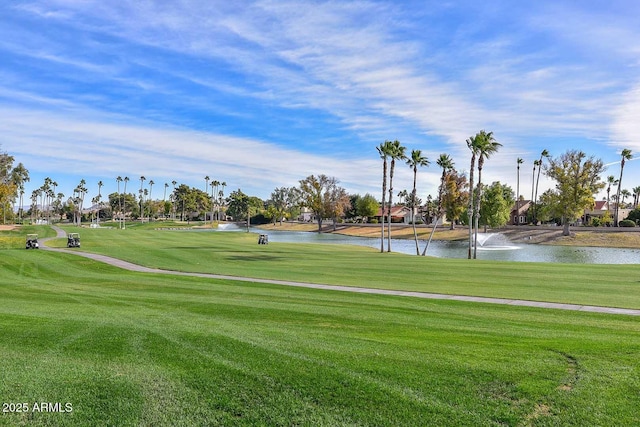 view of home's community featuring view of golf course, a lawn, and a water view